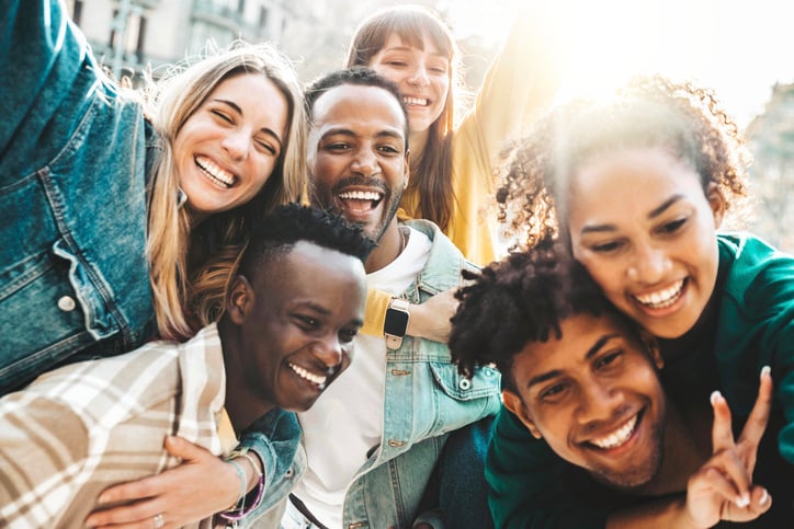 Happy multiracial friends having fun hanging out on city street